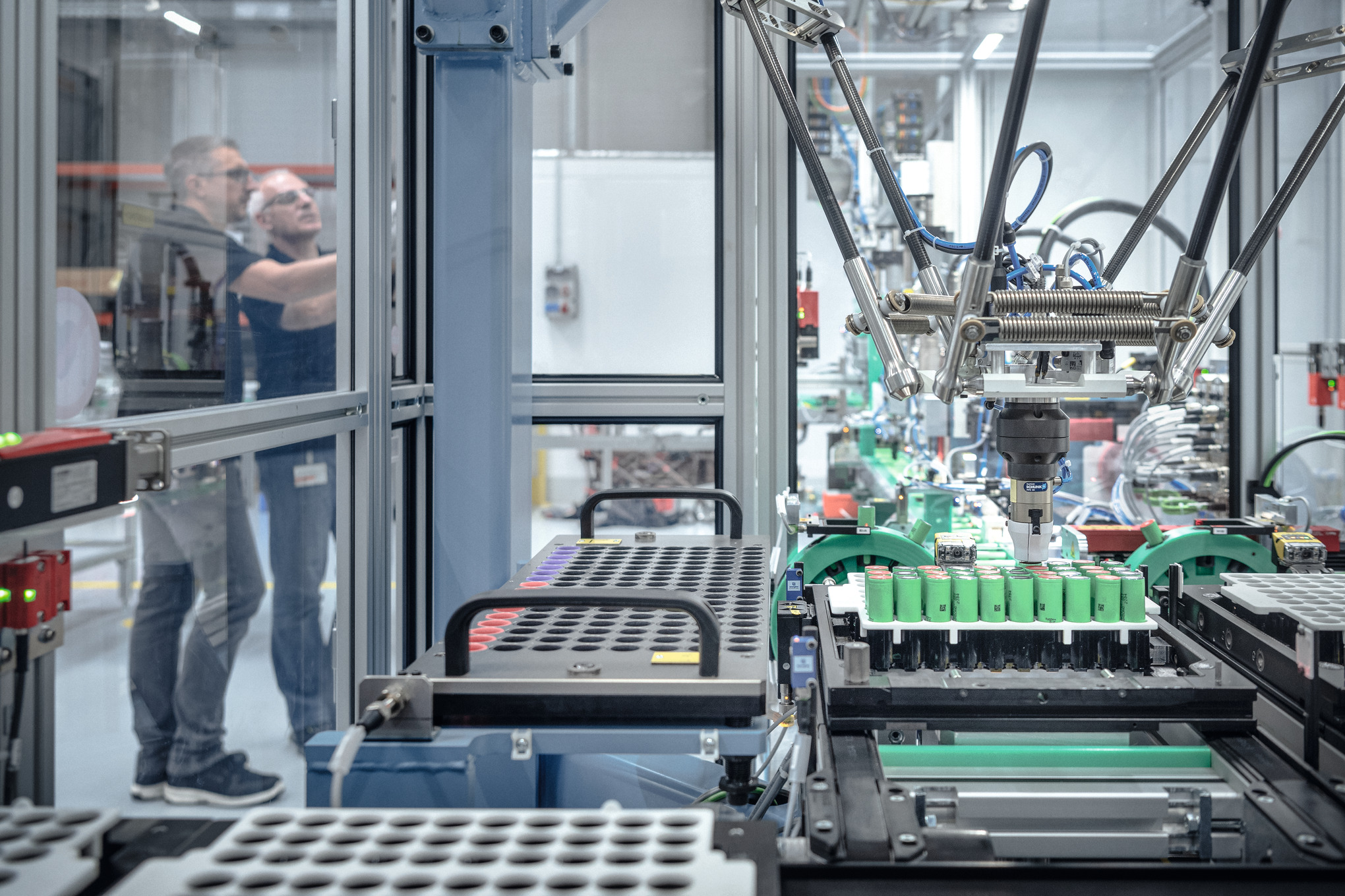 Two men in STIHL battery production surrounded by machines and robots