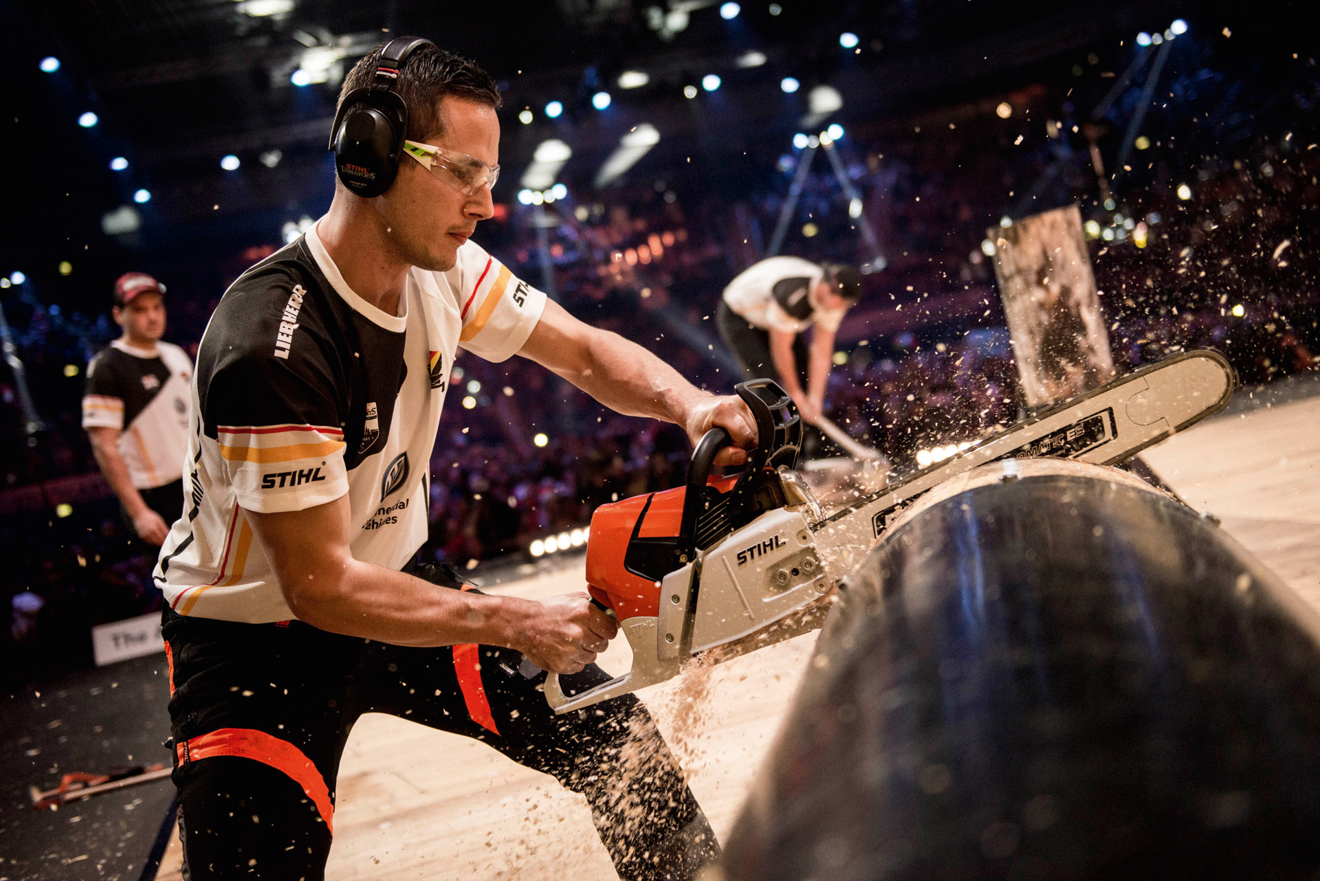 A STIHL TIMBERSPORTS® athlete sawing a tree trunk in a competition 